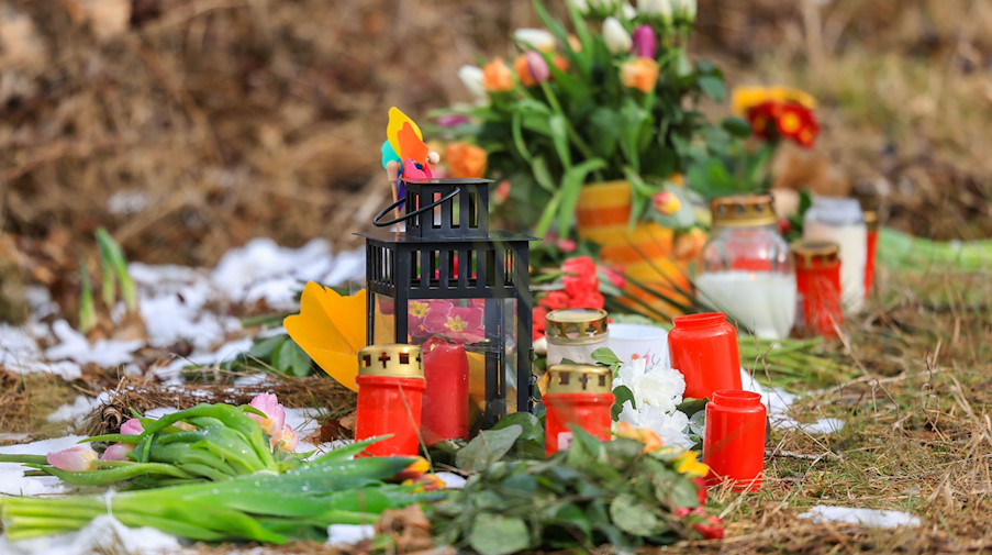 Kerzen und Blumen liegen in einem Wald im südlichen Nordrhein-Westfalen. / Foto: Oliver Berg/dpa