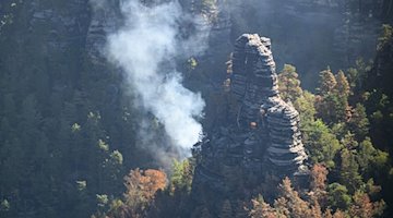 Rauch steigt bei einem Waldbrand im Nationalpark Sächsische Schweiz in den Himmel. / Foto: Robert Michael/dpa/Archivbild