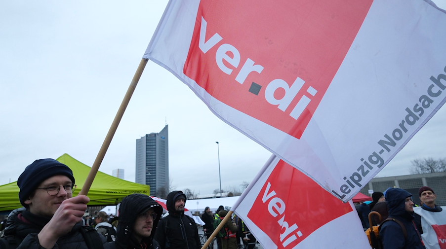 Teilnehmer eines Warnstreiks versammeln sich mit Verdi-Fahnen zu einer Kundgebung. / Foto: Sebastian Willnow/dpa/Symbolbild