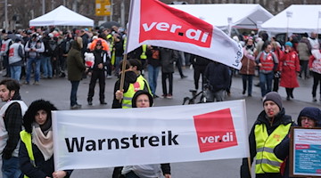 Teilnehmer einer Kundgebung versammeln sich mit Fahnen und Transparenten. / Foto: Sebastian Willnow/dpa/Archivbild