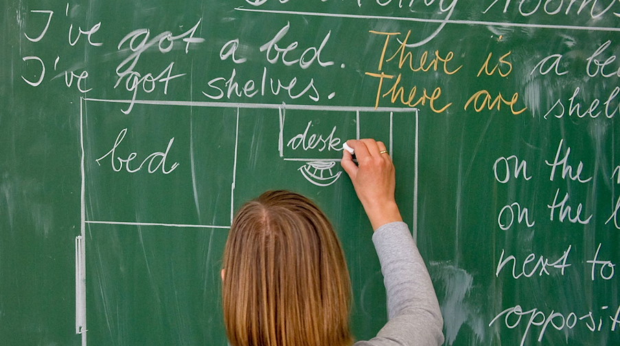 Eine Lehrerin einer Grundschule schreibt in englischer Sprache an die Tafel. / Foto: Patrick Pleul/dpa-Zentralbild/dpa/Symbolbild