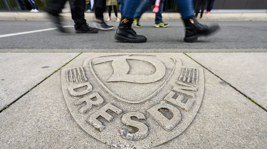 Das Logo der SG Dynamo Dresden ist vor dem Stadion in Beton gegossen. / Foto: Robert Michael/dpa/Archivbild