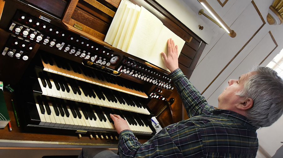 Norbert Britze, spielt nach Noten in Brailleschrift an der Orgel aus dem Jahr 1907. / Foto: Waltraud Grubitzsch/dpa/Produktion