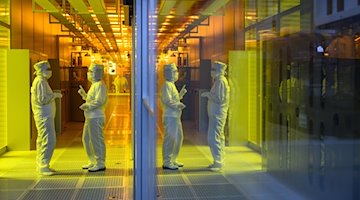 Mitarbeiterinnen des Chipkonzerns Infineon stehen im Reinraum der Chipfabrik. / Foto: Robert Michael/dpa