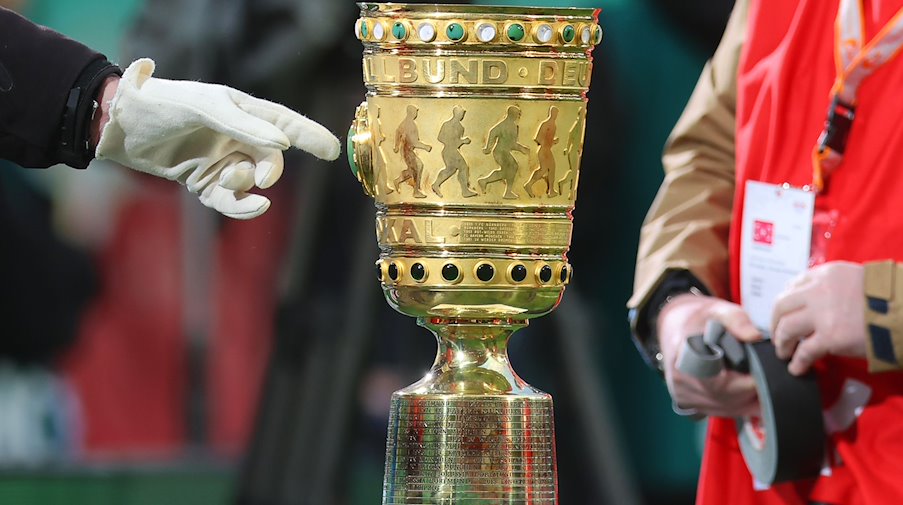 Der DFB-Pokal steht am Rande des Spielfelds. / Foto: Jan Woitas/dpa