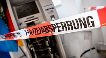 Ein gesprengter Geldautomat ist hinter einem Flatterband mit der Aufschrift «Polizeiabsperrung» zu sehen. / Foto: Matthias Balk/dpa/Symbolbild