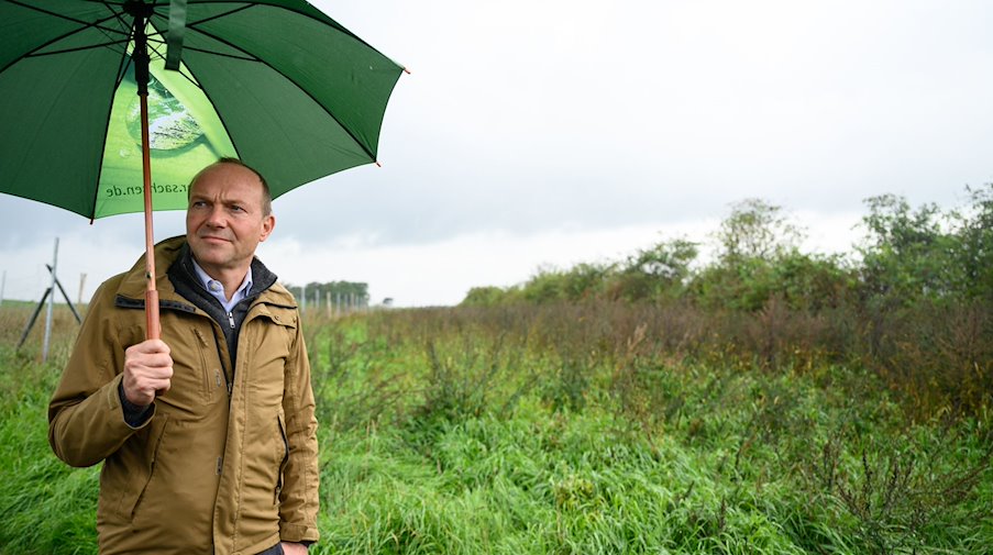 Wolfram Günther (Bündnis90/Die Grünen), Umweltminister von Sachsen, geht mit seinem Regenschirm. / Foto: Robert Michael/dpa/Archivbild