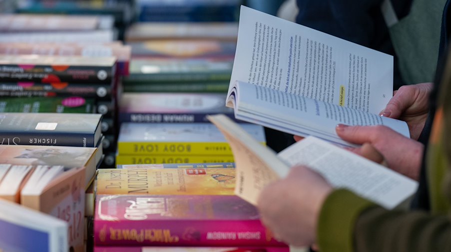Besucherinnen und Besucher der Leipziger Buchmesse verschaffen einen Überblick über das Buchangebot. / Foto: Hendrik Schmidt/dpa