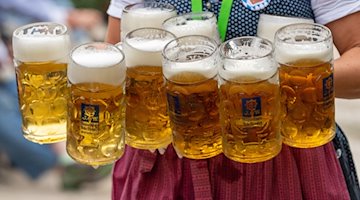 Eine Bedienung trägt acht Maß Bier. / Foto: Peter Kneffel/dpa/Symbolbild
