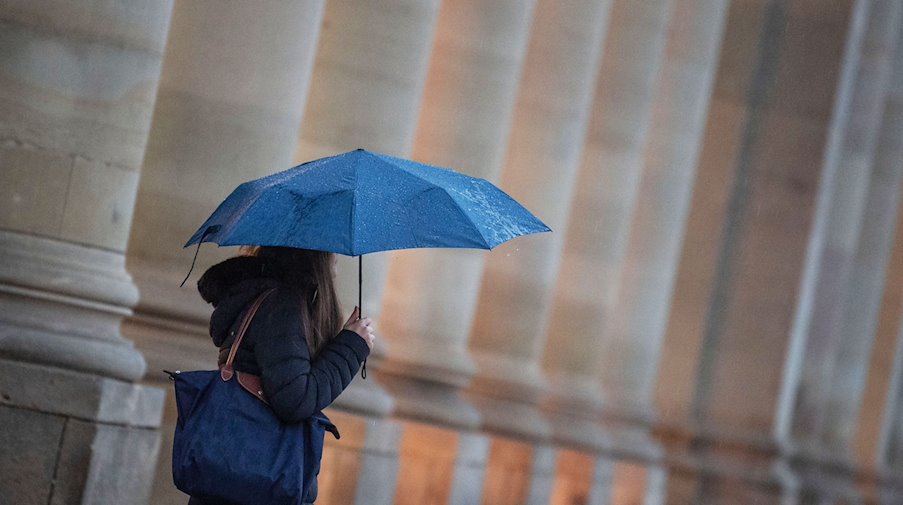 Eine Passantin geht bei Regen durch die Stadt. / Foto: Marijan Murat/dpa/Symbolbild