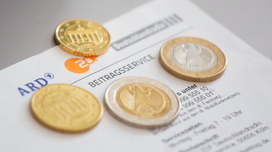 Euromünzen liegen auf einem Anschreiben zur Anmeldung für die Rundfunkgebühren. / Foto: Fernando Gutierrez-Juarez/dpa-Zentralbild/dpa/Symbolbild