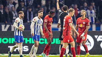 Mohamed Simakan (3.v.l) von RB Leipzig erhält Gelbe Karte von Schiedsrichter Deniz Aytekin. / Foto: Andreas Gora/dpa