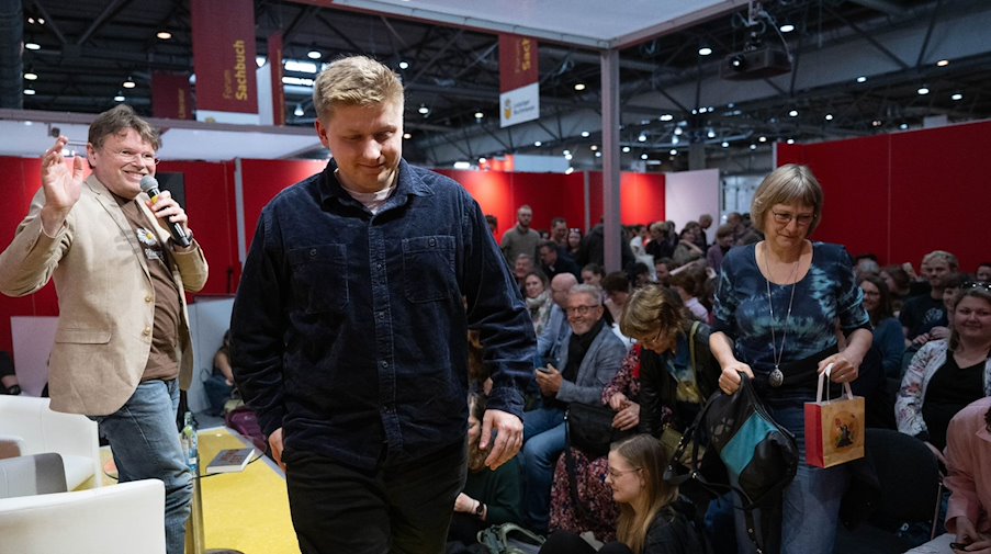 Sebastian Hotz (2.v.l.), der auch «El Hotzo» genannt wird, geht nach einem Auftritt auf der Leipziger Buchmesse von der Bühne. / Foto: Hendrik Schmidt/dpa