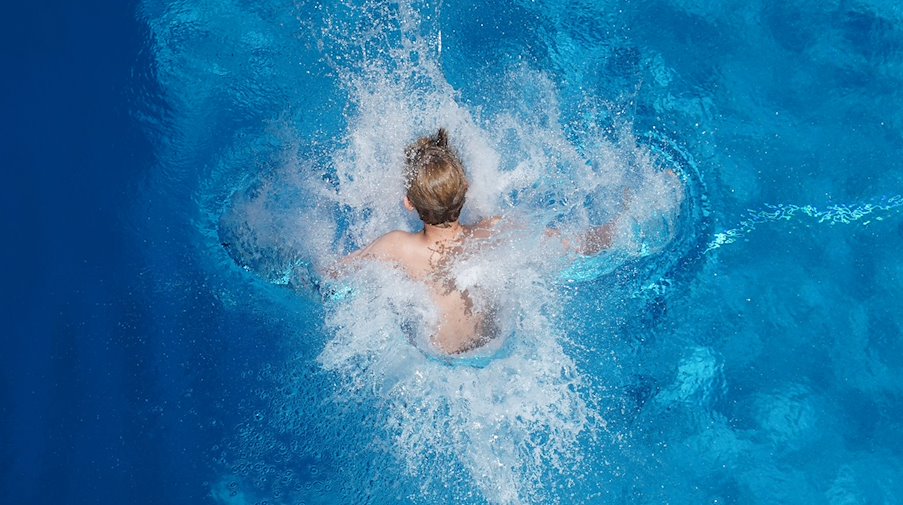 Ein Junge springt in einem Freibad ins Wasser. / Foto: Joerg Carstensen/dpa/Symbolbild