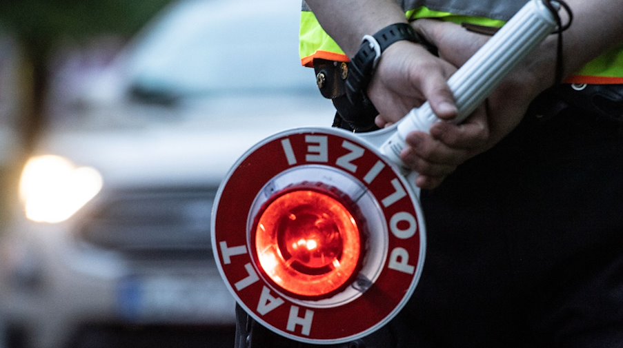 Ein Polizist hält bei einer Verkehrskontrolle eine Winkerkelle in der Hand. / Foto: Paul Zinken/dpa/ZB/Symbolbild