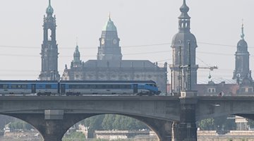Ein sogenannter "Railjet", ein Fernverkehrszug in Kooperation mit der Tschechischen Bahn (CD) und den Österreichischen Bundesbahnen (ÖBB), fährt vor der Kulisse der Altstadt über eine Brücke. / Foto: Sebastian Kahnert/dpa-Zentralbild/dpa