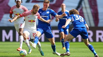 Leipzigs Konrad Laimer (l) im Zweikampf mit Schalkes Marius Bülter. / Foto: Jan Woitas/dpa