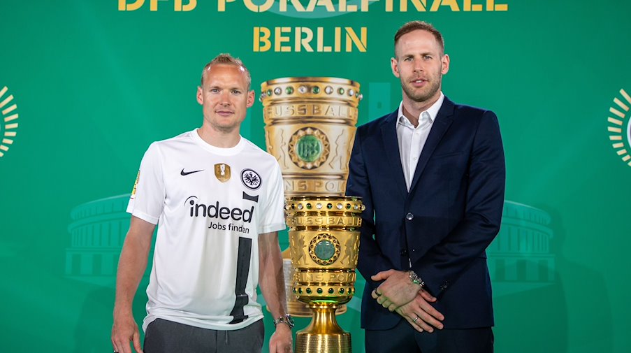 Frankfurts Sebastian Rode (l) und Leipzigs Torhüter Peter Gulacsi stehen beim Cup Handover DFB-Pokal 2023 neben der Trophäe. / Foto: Andreas Gora/dpa