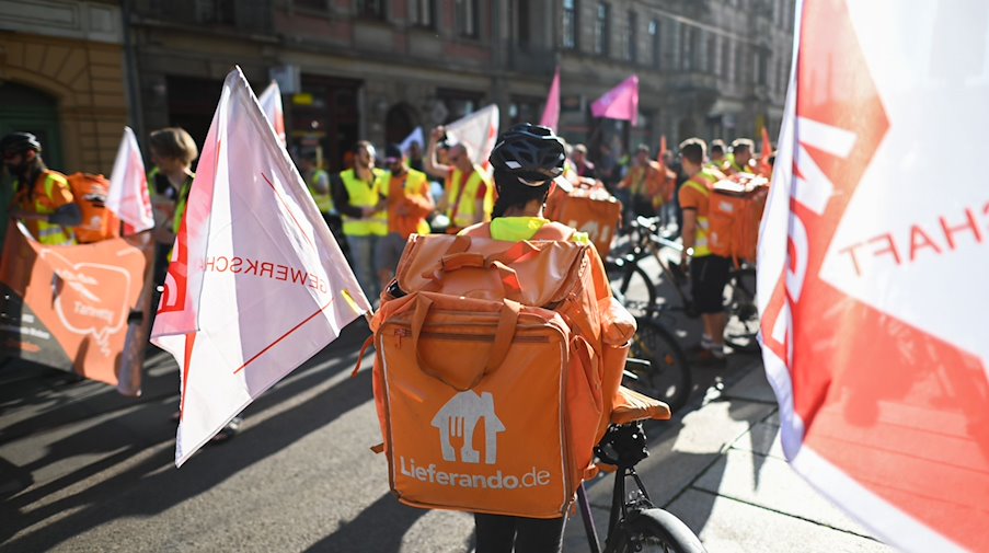Teilnehmer eines Streiks der Kuriere des Restaurant-Lieferdienstes Lieferando fahren mit Rädern und laufen. / Foto: Robert Michael/dpa