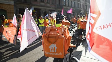 Teilnehmer eines Streiks der Kuriere des Restaurant-Lieferdienstes Lieferando fahren mit Rädern und laufen. / Foto: Robert Michael/dpa