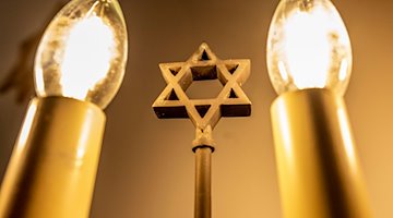 Ein siebenarmiger Leuchter (Menora) mit einem Davidstern in einer Synagoge. / Foto: David Inderlied/dpa/Symbolbild