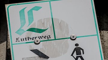 Das Logo des Lutherweges ist auf einem Schild zu sehen. / Foto: Hendrik Schmidt/dpa