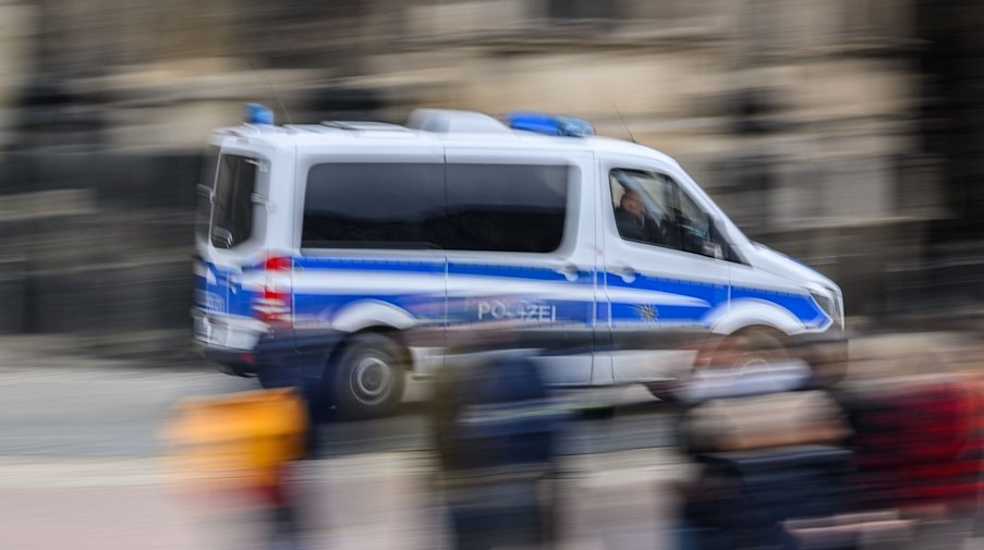 Ein Einsatzwagen der Polizei fährt durch eine Stadt. / Foto: Robert Michael/dpa/Symbolbild