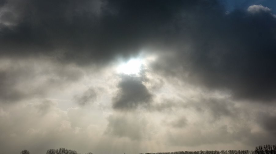 Die Sonne kommt nur kurzzeitig hinter einer dunklen Wolkendecke hervor. / Foto: Jens Kalaene/dpa-Zentralbild/ZB/Symbolbild