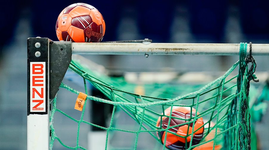 Spielbälle liegen im Netz eines Handball-Tors. / Foto: Uwe Anspach/dpa/Symbolbild