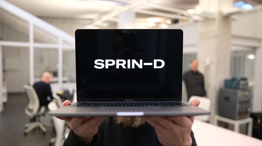Ein Mitarbeiter der Bundesagentur für Sprunginnovationen hält einen Laptop mit dem Schriftzug. / Foto: Sebastian Willnow/dpa/Illustration