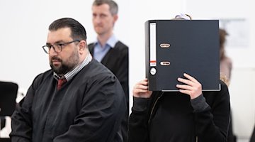 Die Angeklagte Lina E. (r) steht bei der Fortsetzung des Prozesses im Oberlandesgericht. / Foto: Sebastian Kahnert/dpa