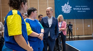Bundeskanzler Olaf Scholz unterhält sich bei seinem Besuch der Handball Wettbewerbe mit Athletinnen. / Foto: Michael Kappeler/dpa