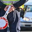 Ein Polizeibeamter hält eine Winkerkelle in den Händen. / Foto: Patrick Pleul/dpa-Zentralbild/ZB/Symbolbild