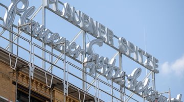 Der Schriftzug „Plauener Spitze bekannt auf dem Weltmarkt“ ist auf einem Industriebau am Rande des Zentrums in Plauen zu sehen. / Foto: Hendrik Schmidt/dpa