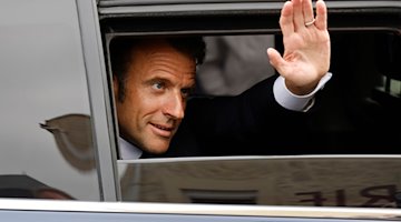 Frankreichs Präsident Emmanuel Macron winkt aus einem Autofenster. / Foto: Ludovic Marin/AFP POOL/AP/dpa