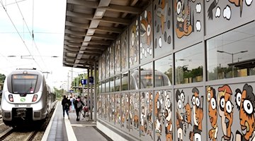 Im Bahnhof Borna fährt eine S-Bahn an einer vom Künstler Michael Fischer-Art bemalten Wand am Bahnsteig 1 vorbei. / Foto: Waltraud Grubitzsch/dpa