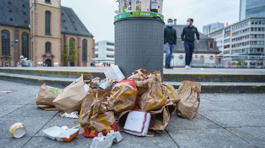 Müll liegt neben einem überfüllten Abfallbehälter. / Foto: Frank Rumpenhorst/dpa