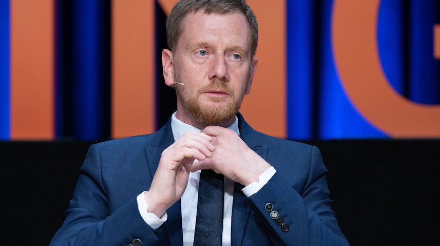 Michael Kretschmer (CDU), Ministerpräsident von Sachsen, sitzt während einer Podiumsdiskussion im Rahmen einer Wissenschaftskonferenz auf seinem Platz. / Foto: Sebastian Kahnert/dpa