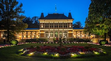 Bunte Lichter strahlen das Königliche Kurhaus der Erlebnis- und Lichterwelt in Bad Elster an. / Foto: Kristin Schmidt/dpa-Zentralbild/dpa