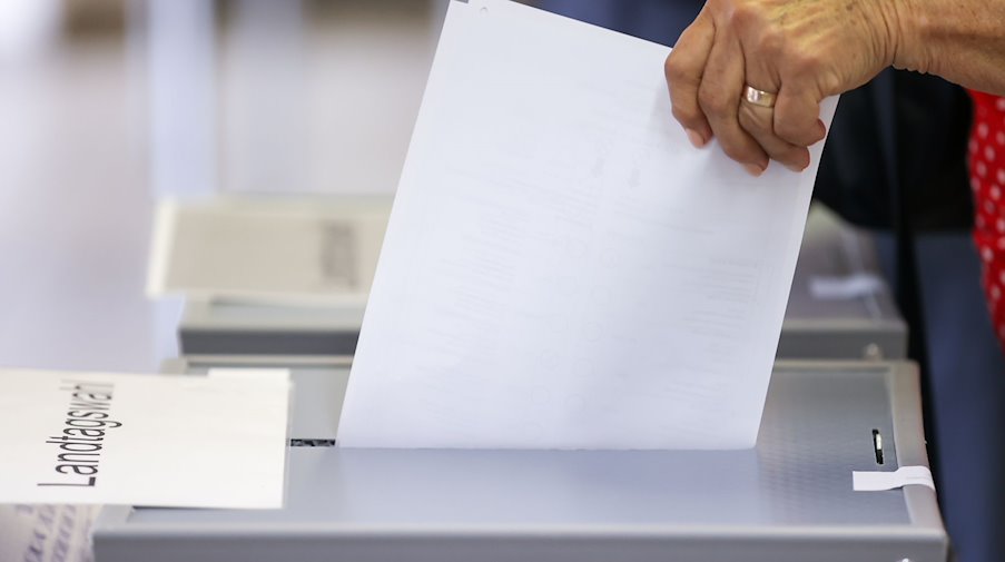 Eine Frau wirft ihren Stimmzettel in eine Urne in einem Wahllokal. / Foto: Jan Woitas/dpa-Zentralbild/dpa/Symbolbild