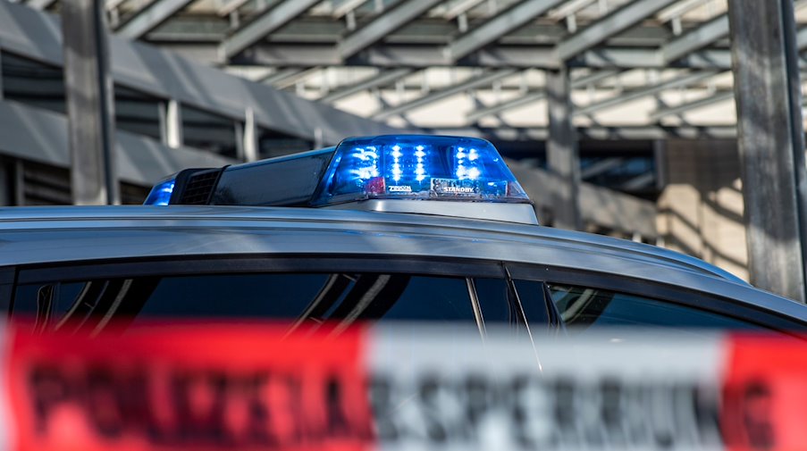 Ein Polizei-Blaulicht leuchtet über einem Absperrband mit der Aufschrift «Polizeiabsperrung». / Foto: David Inderlied/dpa/Illustration