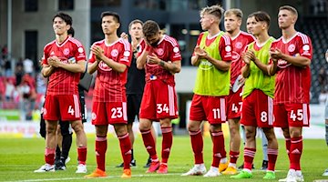 Düsseldorfs damaliger Spieler Niko Vukancic (3. v. r.) steht mit seinem Team auf dem Feld. / Foto: Tom Weller/dpa/Archiv