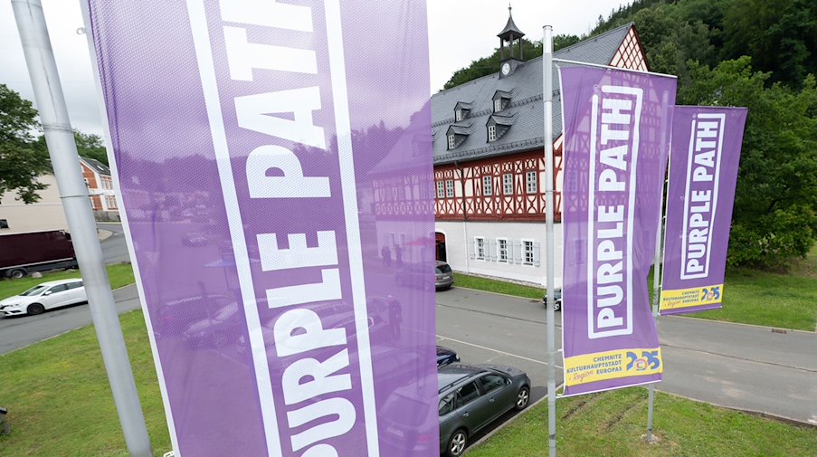 Fahnen mit mit dem Schriftzug „Purple Path“ hängen vor dem Herrenhaus Auerhammer. / Foto: Sebastian Kahnert/dpa-Zentralbild/dpa