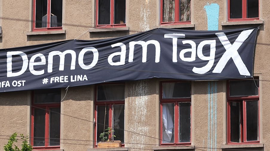Ein Transparent mit der Aufschrift "Demo am Tag X» und "# Free Lina" hängt an der Fassade eines Hauses im Osten der Stadt. / Foto: Sebastian Willnow/dpa/Archivbild