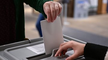 Ein Wähler steckt bei einer Wahl seinen Wahlzettel in eine Urne. / Foto: Bernd Weißbrod/Deutsche Presse-Agentur GmbH/dpa/Symbolbild