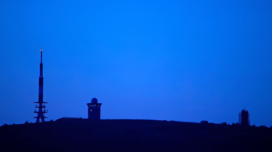 Im Licht der Abenddämmerung steht der Brocken am Horizont. / Foto: Matthias Bein/dpa