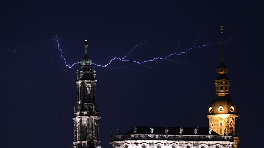 Blitze entladen sich während eines Gewitters am Abend über der Altstadt am Himmel. / Foto: Robert Michael/dpa