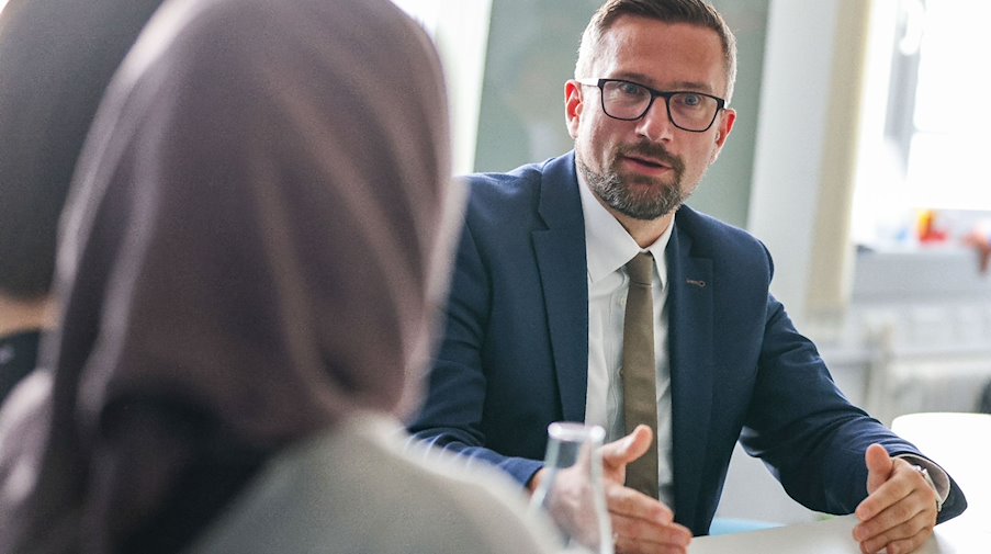 Sachsens Wirtschaftsminister Martin Dulig (SPD), spricht mit Mitarbeiterinnen aus dem Jemen. / Foto: Jan Woitas/dpa