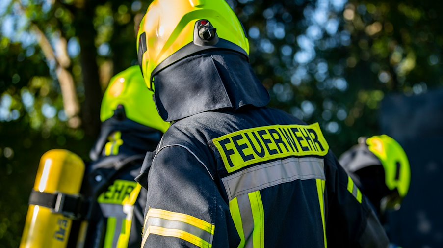 Feuerwehrleute stehen zusammen, um den Einsatz zu besprechen. / Foto: David Inderlied/dpa/Symbolbild