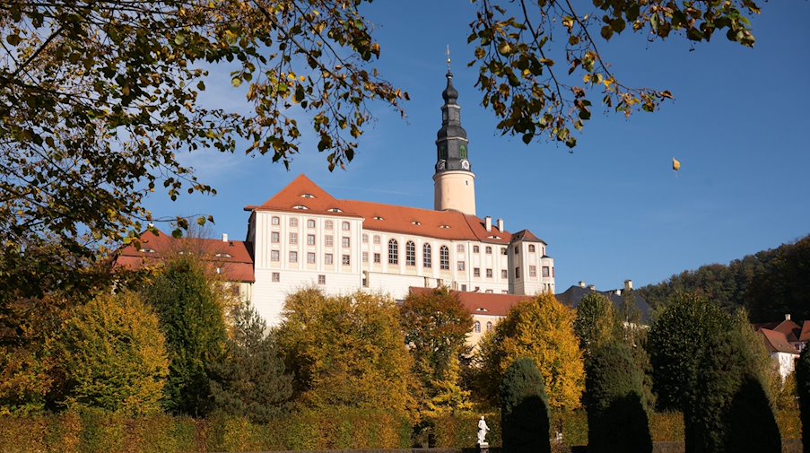 Herbstlich gefärbte Bäume rahmen das Schloss Weesenstein. / Foto: Sebastian Kahnert/dpa/Archivbild